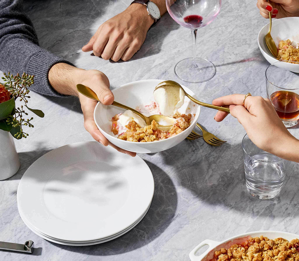 couple eating in white serving bowl with an empry ceramic plates