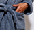 Close up of model wearing Slate Blue Classic bathrobe with their hand in their pocket.
