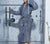 Woman coming out of the shower wearing a Slate Blue Classic Bathrobe.