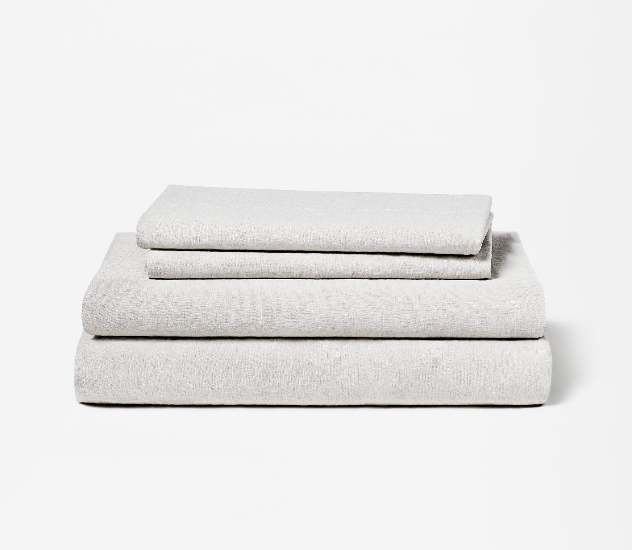 Folded set of two Ash Grey Linen Pillow Cases on top of a folded Linen Fitted Sheet and Flat Sheet.