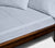 Wooden bed with close up of two Slate Blue Linen pillows and sheets.