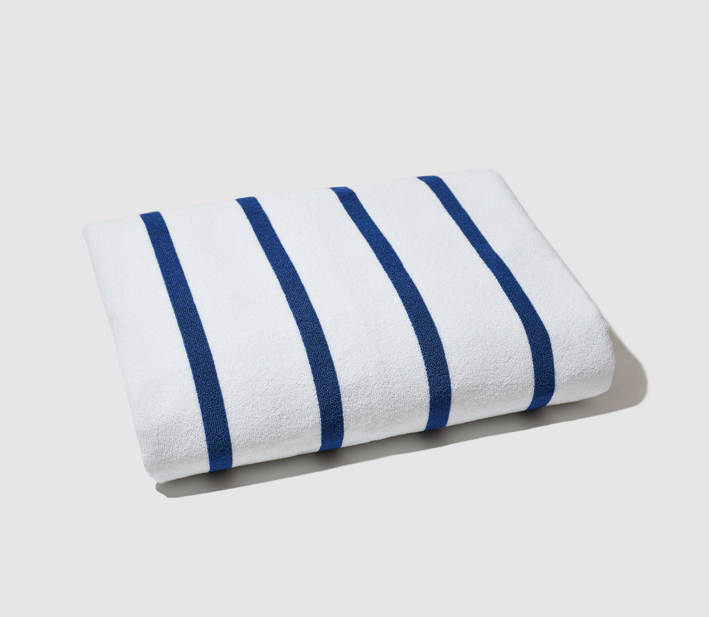 Folded Blue Sunny Stipe Beach Towel with a white background.