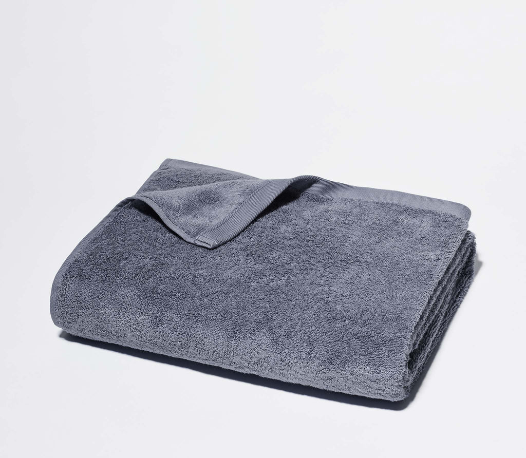 Folded Slate Blue Classic Bath Towel with white background.
