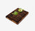 End-Grain hand crafted, black walnut, rectangular cutting board with two artichoke pieces on it, with a white background.