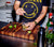 Man standing in white kitchen, mixing a drink on the End-Grain hand crafted, black walnut, rectangular cutting board.  Barware and mixers around. 