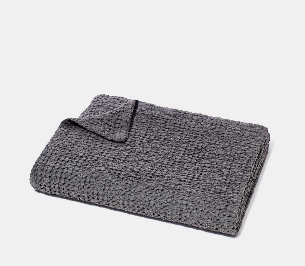 Folded Charcoal Grey Honeycomb Bath Towel with white background.